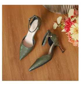 Detailed view of olive green crocodile pattern high heels with elegant ankle straps.