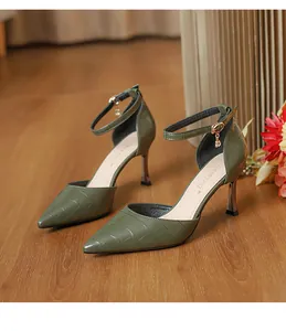 Detailed view of olive green crocodile texture pointed-toe high heels with ankle straps