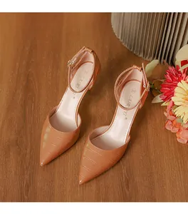 High angle detail shot of tan crocodile embossed pointed toe pumps with ankle strap