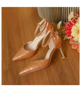 Macro view of caramel croc-patterned pointed-toe stiletto heels with elegant ankle strap