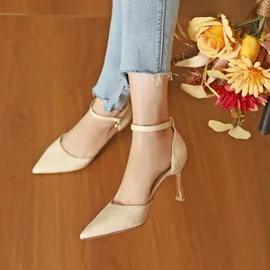 Elegant beige crocodile-patterned stiletto heels with pointed toe and ankle strap.