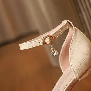 Elegant beige croco pattern high heel sandals featuring a sparkling rhinestone charm detail