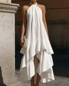 Dettaglio vestito lungo bianco allacciato al collo con volant asimmetrici estivo.