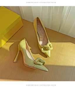 Elegant pale yellow patent leather pointed toe stiletto heels with a bold chain link detail