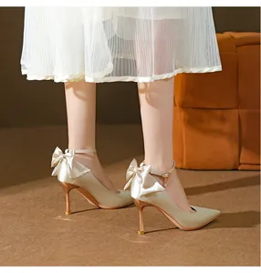 Detailansicht von eleganten Seiden-Pumps in Champagner mit Schleife und Fesselriemen