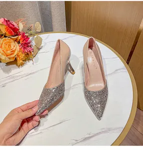 Vue rapprochée de chaussures à talons aiguilles pailletées argentées à bout pointu.