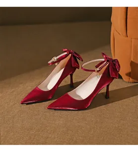 Elegante rote Seiden-Pumps mit Knöchelriemen, spitzer Kappe und Seidenschleife hinten.