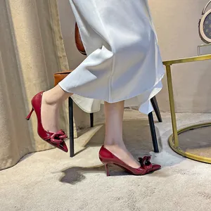 Deep red pointed-toe patent leather stiletto high heels with decorative chain detail