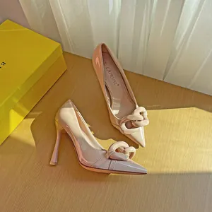Elegant nude patent leather pointed-toe stiletto pumps with chunky chain detail.