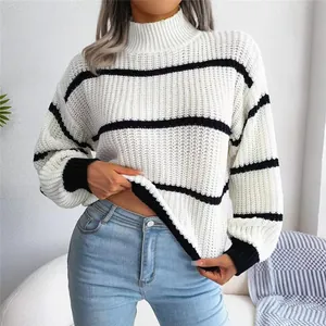 Close-up detail of a white knit sweater featuring black stripes and lantern sleeves.