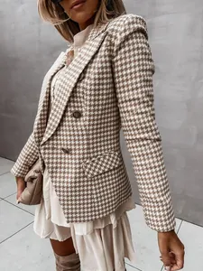 Dettaglio di un elegante blazer pied-de-poule marrone e bianco con bottoni metallici