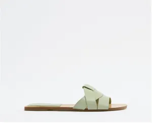 Sandalo basso minimalista verde chiaro con punta quadrata e cinturini incrociati
