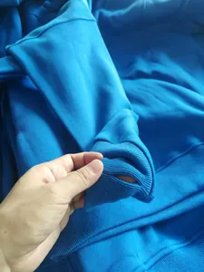 Detail view of a bright blue fleece hoodie cuff highlighting the functional thumbhole design.