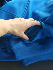 Close-up detail showing the pocket and soft fleece texture of the blue warm hoodie.