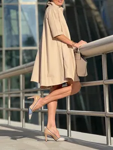 Robe chemise évasée beige élégante avec manches courtes portée par un mannequin