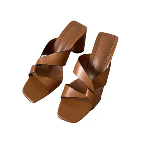 Sandali marroni minimalisti con tacco largo, cinturini incrociati e punta aperta da donna.