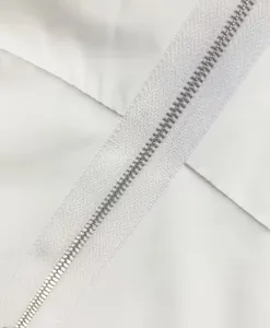 Close-up macro detail of the white zipper on elegant sleeveless commuter jumpsuit fabric