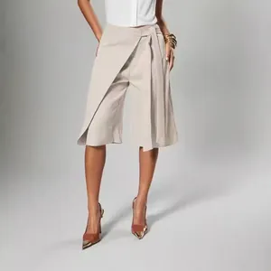 Close-up detail of beige wrap-style wide-leg culottes with an adjustable waist tie design.