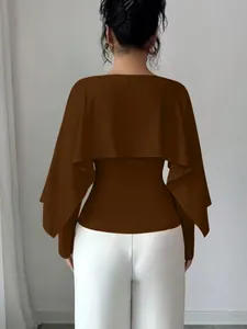 Vista posterior detallada de un elegante top marrón estilo capa con diseño de cuello redondo