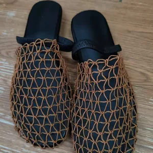 Detailed view of brown hollow mesh woven flat slippers with a breathable summer design