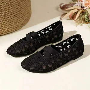 Vue détaillée des chaussures Mary Jane en dentelle florale noire avec brides croisées.