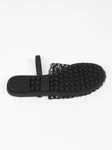 Detailed bottom view of black woven flat sandal showing non-slip sole and size mark.