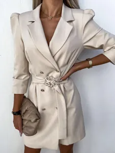 Close-up detail of beige puff sleeve double-breasted blazer dress with crystal buckle belt