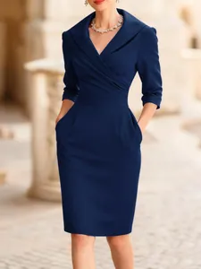 Detail view of navy blue wrap dress with elegant shawl collar and waist pleats