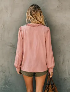 Achteraanzicht van een roze overhemd met lange mouwen, elegante ruffelkraag en casual textuur.