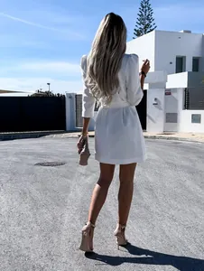 Full back view of a stylish white blazer dress with a waist tie in a street setting