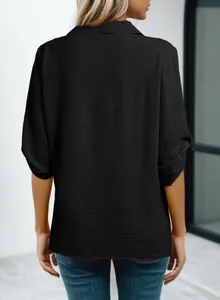 Vista posterior de una blusa negra de manga media con elegantes detalles de textura
