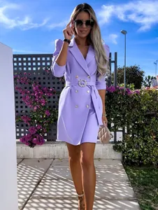 Detail view of a purple double-breasted blazer dress with puff sleeves and belt.