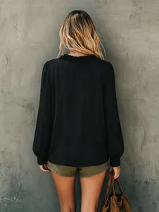Achteraanzicht van zwarte blouse met lange mouwen, rucheskraag en zachte gestructureerde stof