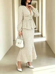 Full-body shot of elegant polka dot V-neck top and matching maxi skirt set with lace