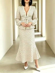 Full view of elegant cream and black polka dot V-neck top with matching mermaid skirt set