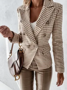Primo piano di un elegante blazer doppiopetto pied de poule con bottoni dorati e revers.