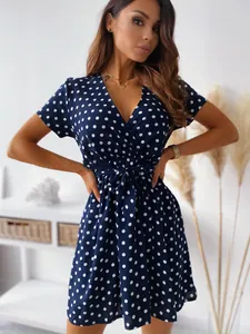 Elegante abito corto blu navy a pois bianchi con scollo a V e cintura da annodare