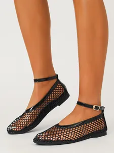 Détail des chaussures plates en résille noire avec design ajouré et bride cheville.