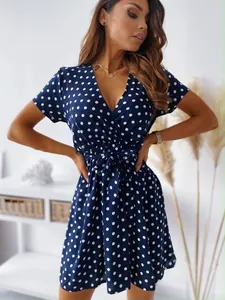 Primo piano del vestito a pois blu scuro con scollo a V, maniche corte e laccetto.