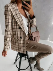 Elegante giacca blazer scozzese da donna con borsa a sella marrone e pantaloni.
