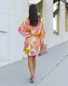 Vue arrière d'une robe chemise à imprimé géométrique coloré portée en milieu urbain.