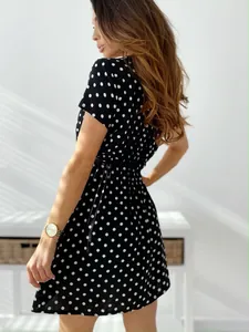 Elegante vista posteriore di un abito estivo a pois bianchi e neri con maniche corte e