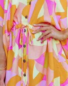 Détail de la robe chemise à imprimé abstrait avec cordon à la taille et boutons en bois