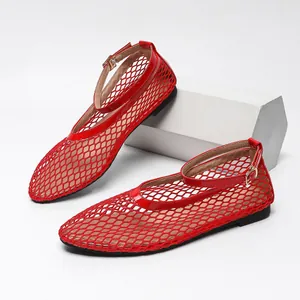 Détail rapproché d'élégantes chaussures plates en maille rouge avec bride à la cheville pour femme