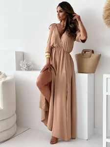 Elegant beige V-neck maxi dress with high side slit and shoulder ties detail.