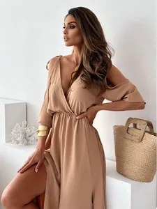 Model wearing a sexy beige V-neck cold shoulder maxi dress with a side slit detail