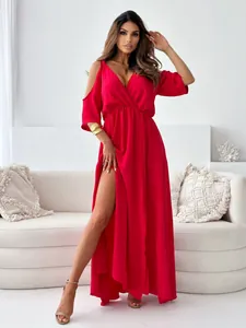 Model wearing a vibrant red V-neck maxi dress with a high side slit and cold shoulders