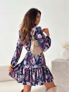 Vista posteriore di un elegante abito a camicia blu navy con stampa floreale e volant