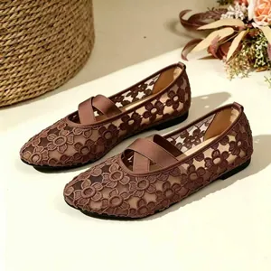 Détail des chaussures Mary Jane en dentelle marron avec broderie florale et brides.