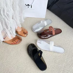 Gros plan de sandales à bout fendu pour femmes en plusieurs couleurs sur un tapis texturé
